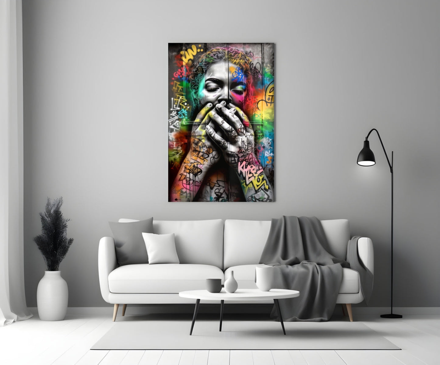 Colorful graffiti-style glass wall art depicting a contemplative face with vibrant multicolored street art background, displayed above a white sofa in a modern living room.