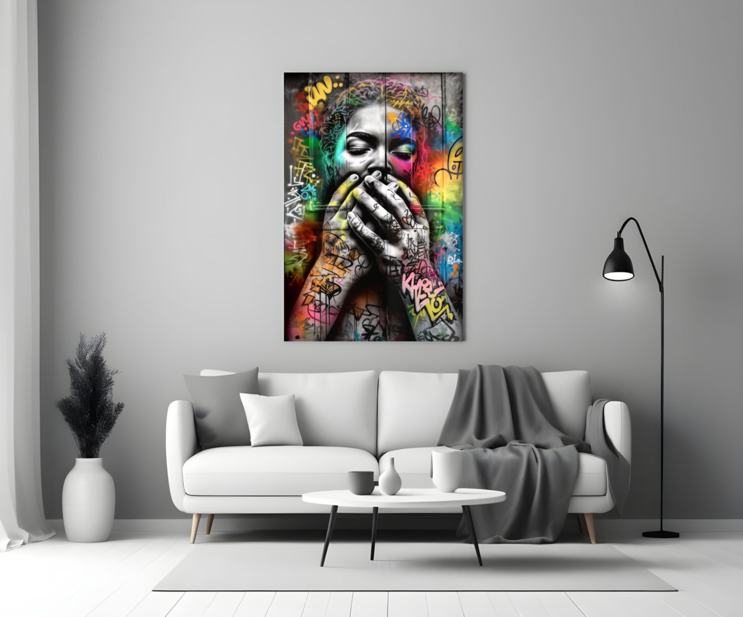 Colorful graffiti-style glass wall art depicting a contemplative face with vibrant multicolored street art background, displayed above a white sofa in a modern living room.