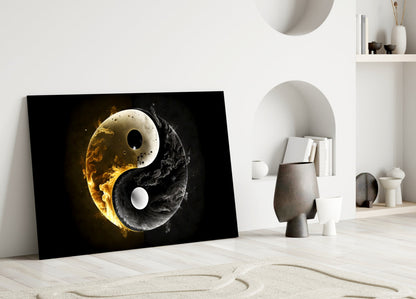 Yin-yang glass wall art leaning against white wall in minimalist room, featuring golden fire and black smoke design on black background.