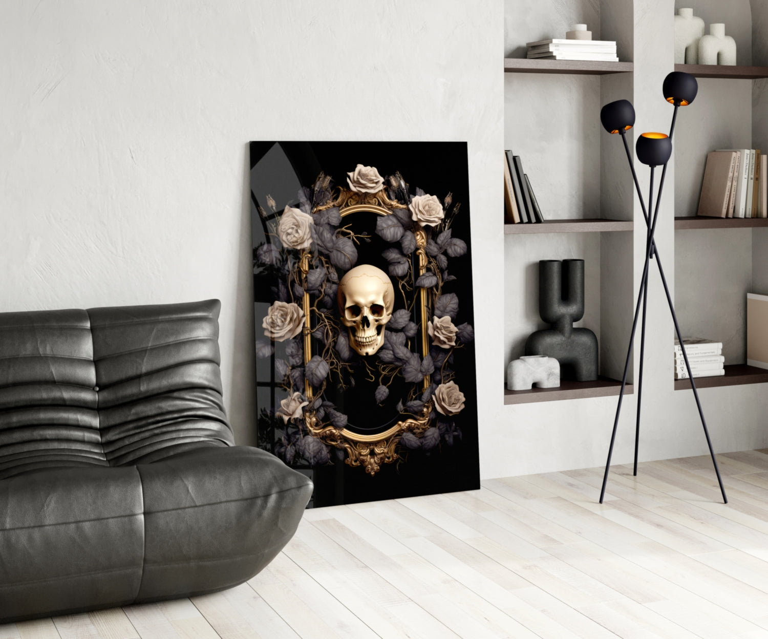Modern living room interior displaying skull portrait glass wall art leaning against white wall beside gray leather chair and black floor lamp.
