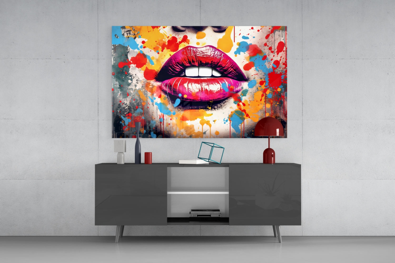 Vibrant pop art glass wall panel featuring colorful splattered lips displayed above gray media console in modern interior setting.