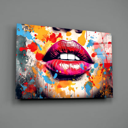 Angled perspective of vibrant glass wall art featuring glossy magenta lips surrounded by colorful paint splatters on white background.