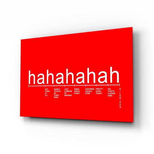 Bright red glass wall art panel displayed at an angle, showing "hahahaha" text with a humor intensity scale ranging from "not funny at all" to "hilarious" printed below.