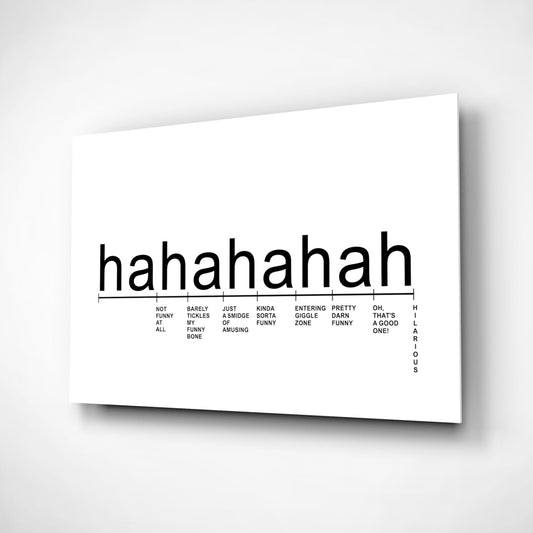 White glass wall art panel displaying "hahahaha" text with a humor intensity scale chart below, mounted at an angle showing depth and shadow on gray background.