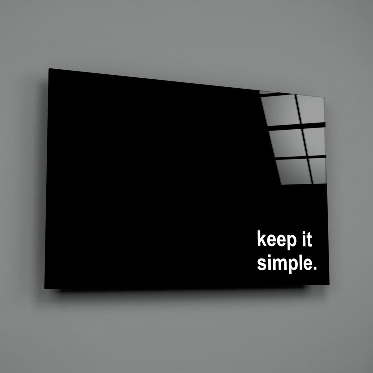 Black glass wall art panel with six small rectangular window panes in upper right corner and white "keep it simple." text, angled three-quarter view against gray background.