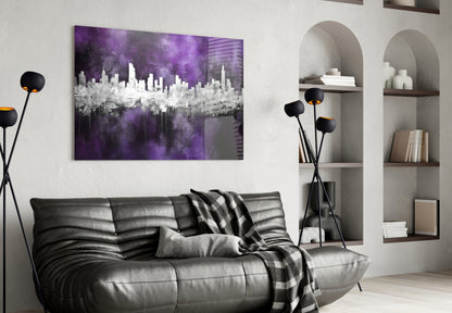 Purple and white cityscape glass wall art hanging above a black leather sofa in a modern living room setting.