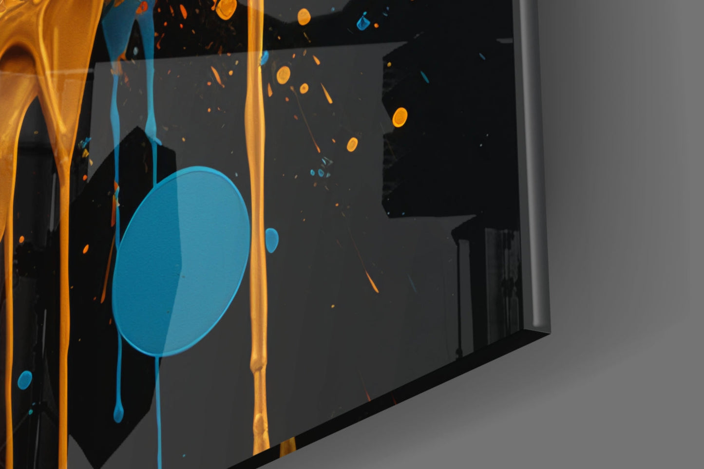 Close-up angled view of glass wall art featuring blue dripping circle with orange and gold streaks on dark background.