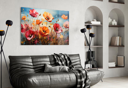 Vibrant poppy flower glass wall art in red, orange, and pink tones displayed above a black leather sofa in a modern living room.
