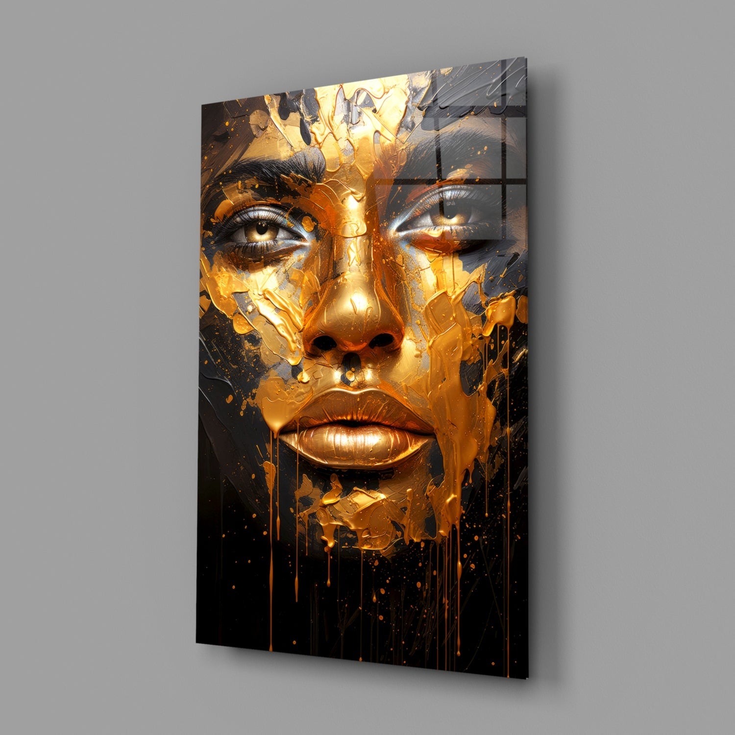 Gold and black glass wall art depicting a stylized face with dripping melted effect, displayed at angle against gray wall.