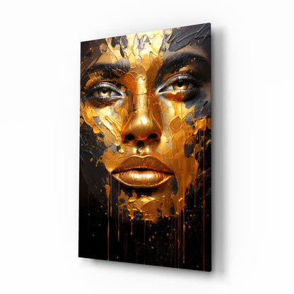 Glass wall art featuring a woman's face with gold and black dripping paint effect, angled perspective showing depth and shadow.