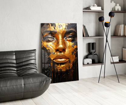 Modern living room interior with golden and black face portrait glass art leaning against white wall beside gray leather chair.