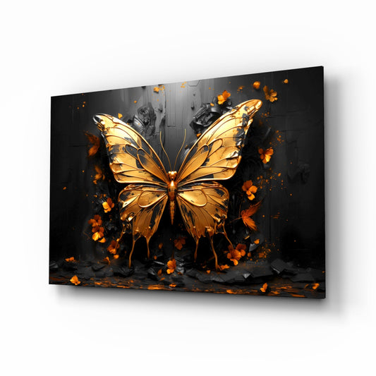 Golden butterfly glass wall art displayed at an angle against white background, showing luminous amber wings with black veins and scattered orange petals.
