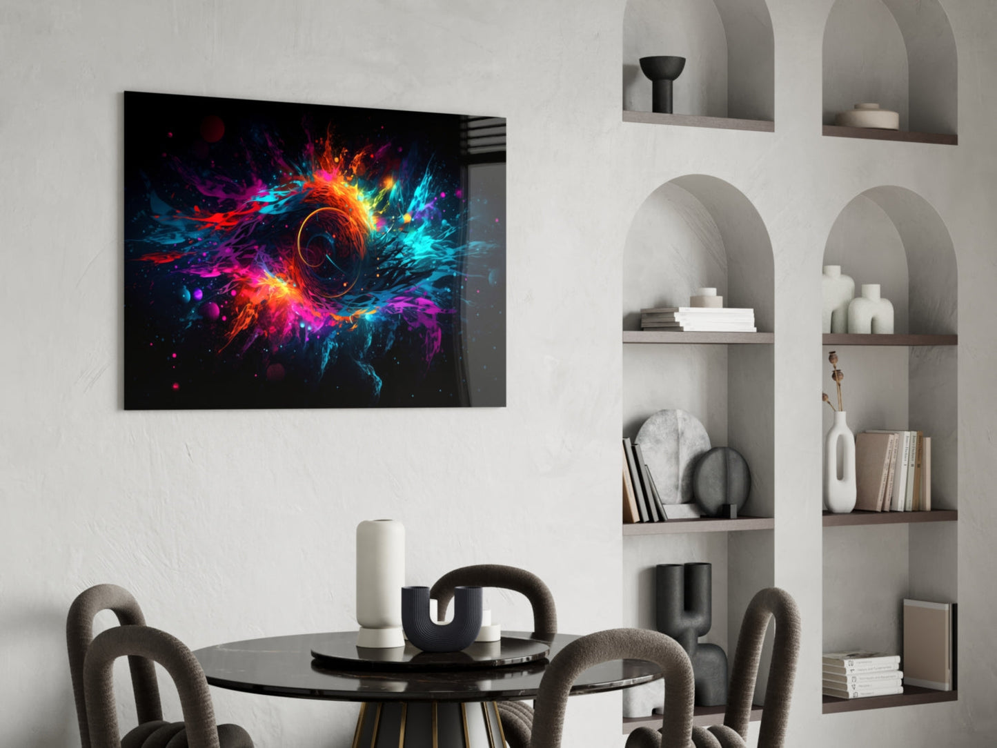Colorful Hole Glass Wall Art mounted above a round black dining table with gray chairs, displaying vibrant neon orange, pink, cyan, and purple explosion design on black background.