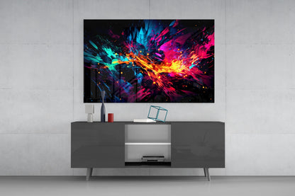 Colorful abstract glass wall art with cyan, magenta, yellow, and orange bursts displayed above a dark gray TV console in a modern living room setting.