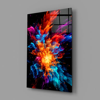 Angled perspective of a glass wall panel displaying a vibrant multicolored explosion of red, orange, yellow, blue, cyan, magenta, and purple particles radiating from a bright center against black background.