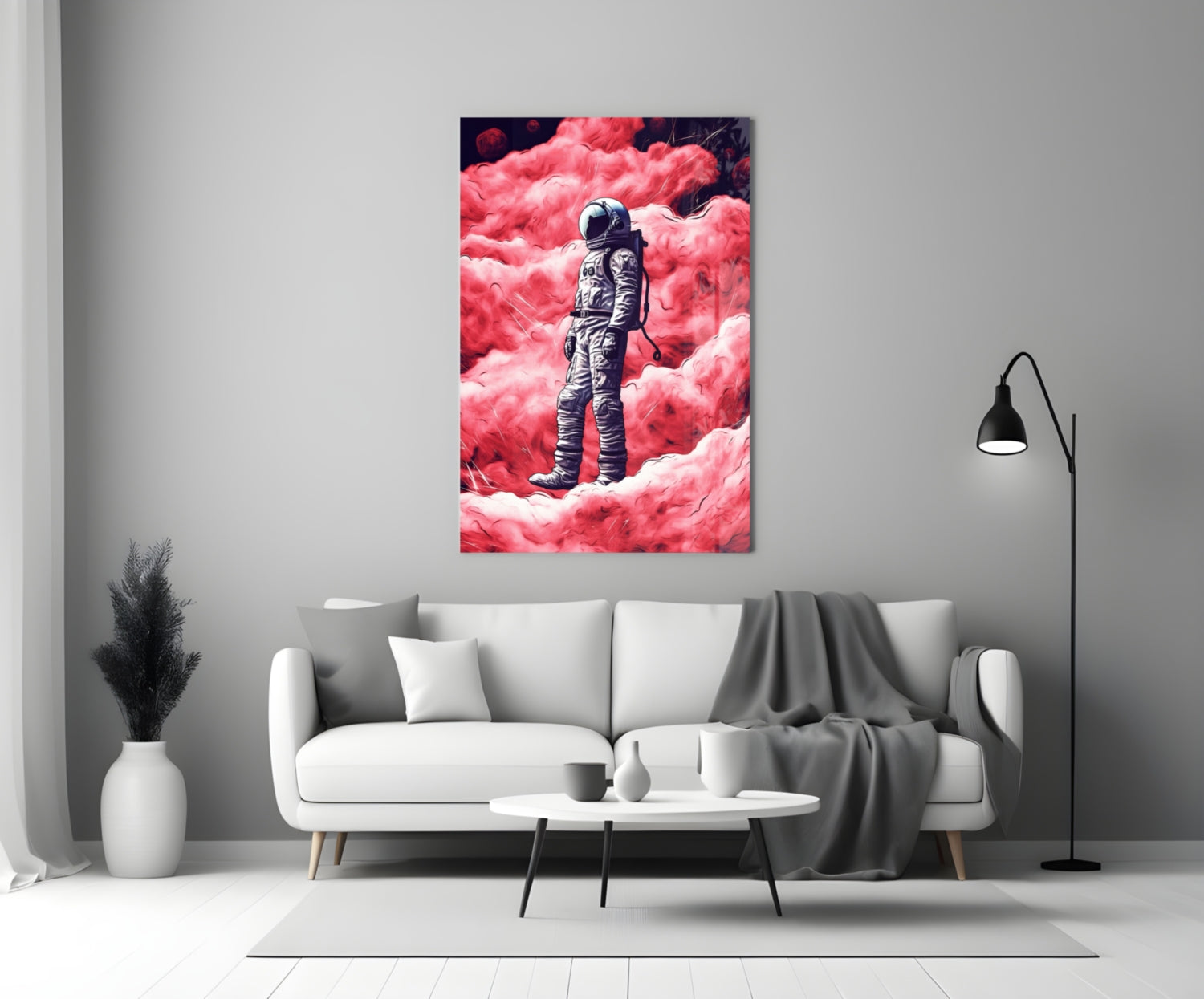Glass wall art depicting an astronaut in spacesuit standing on a vibrant pink cloudy landscape, displayed above a white sofa in a modern living room.