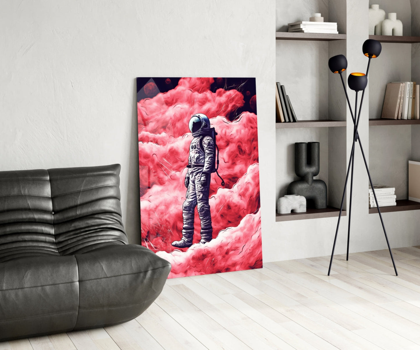 Modern living room interior featuring astronaut glass wall art displaying a suited figure against vibrant pink clouds, positioned beside black leather furniture.