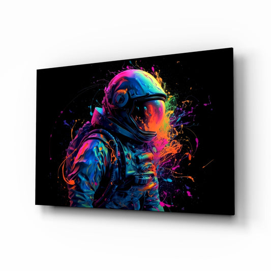 Angled perspective of neon-colored glass wall art featuring an astronaut in a helmet surrounded by vibrant paint splashes in pink, blue, orange, and yellow on black background.