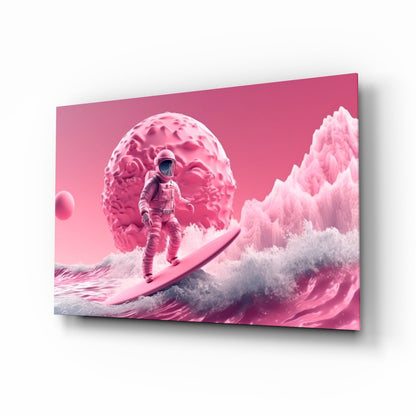 Pink-toned glass wall art displaying an astronaut surfing on waves beneath a textured brain-shaped planet, angled perspective view.