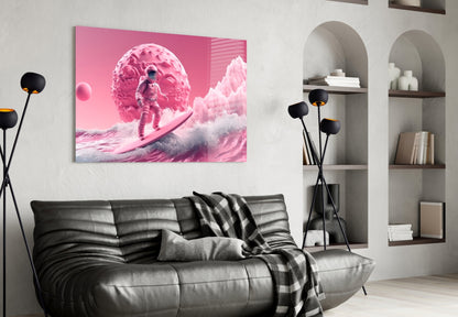 Pink and white glass wall art depicting an astronaut on a surreal landscape, displayed above a black leather sofa in a modern interior setting.