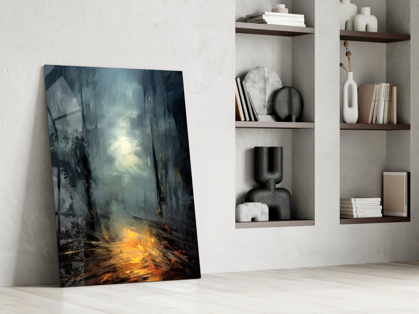 Glass wall art leaning against white wall beside floating shelves with decorative objects, featuring moody forest scene with golden light.