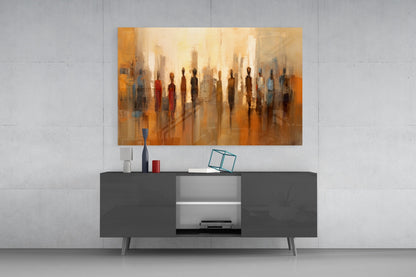 Abstract glass wall art depicting silhouetted figures in warm golden and orange tones displayed above a dark modern console table.