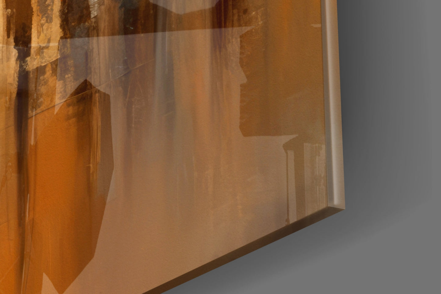 Close-up detail of amber and bronze silhouette glass panel showing layered architectural forms and textures against neutral background.