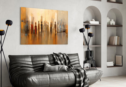Modern living room with gold-toned glass art depicting silhouetted figures displayed above black leather sofa.