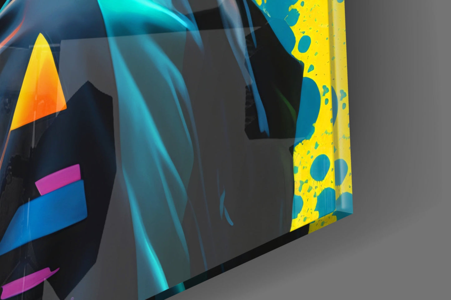 Close-up angled view of colorful glass wall art panels featuring geometric shapes in yellow, blue, magenta, and orange against dark backgrounds.