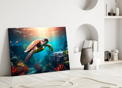 Sea turtle glass wall art leaning against white wall in minimalist room setting with sand and decorative objects.