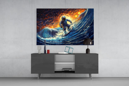 Framed glass wall art displaying an astronaut surfing on a cosmic wave with orange and blue tones, mounted above a dark gray media console in a modern living room setting.