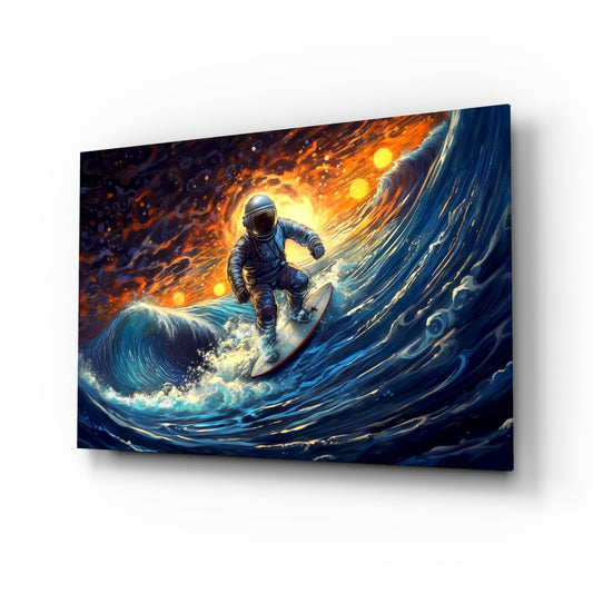 Angled perspective of glass wall art depicting an astronaut surfing a luminous blue wave against a fiery orange and gold sky background.