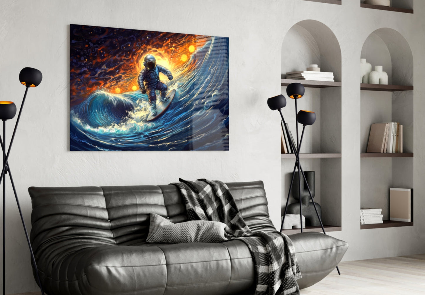 Modern living room with black leather sofa displaying vibrant glass wall art of astronaut surfing on glowing blue wave.