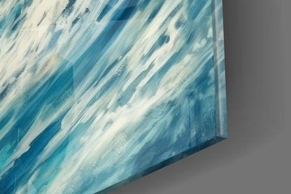 Close-up angled view of glass wall art showing diagonal brushstrokes in shades of blue and white.