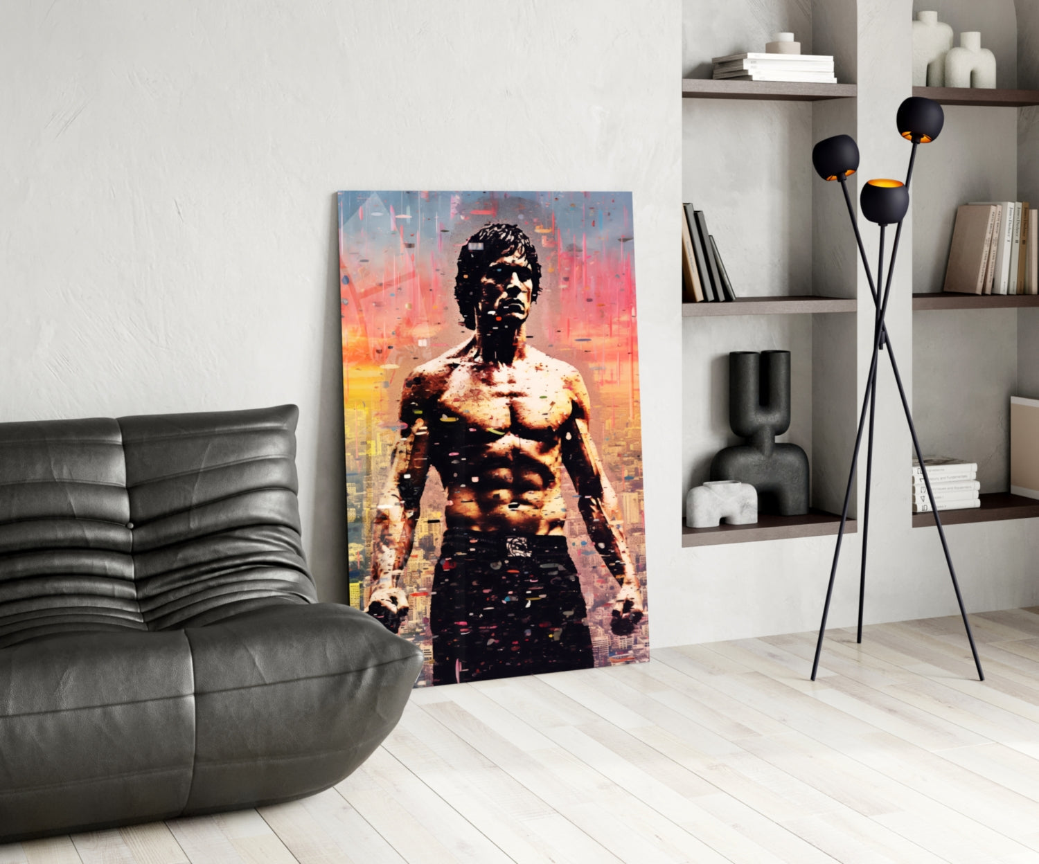 Modern living room with glass wall art depicting a shirtless man against an orange and blue cityscape backdrop, displayed beside a black leather chair and floor lamp.