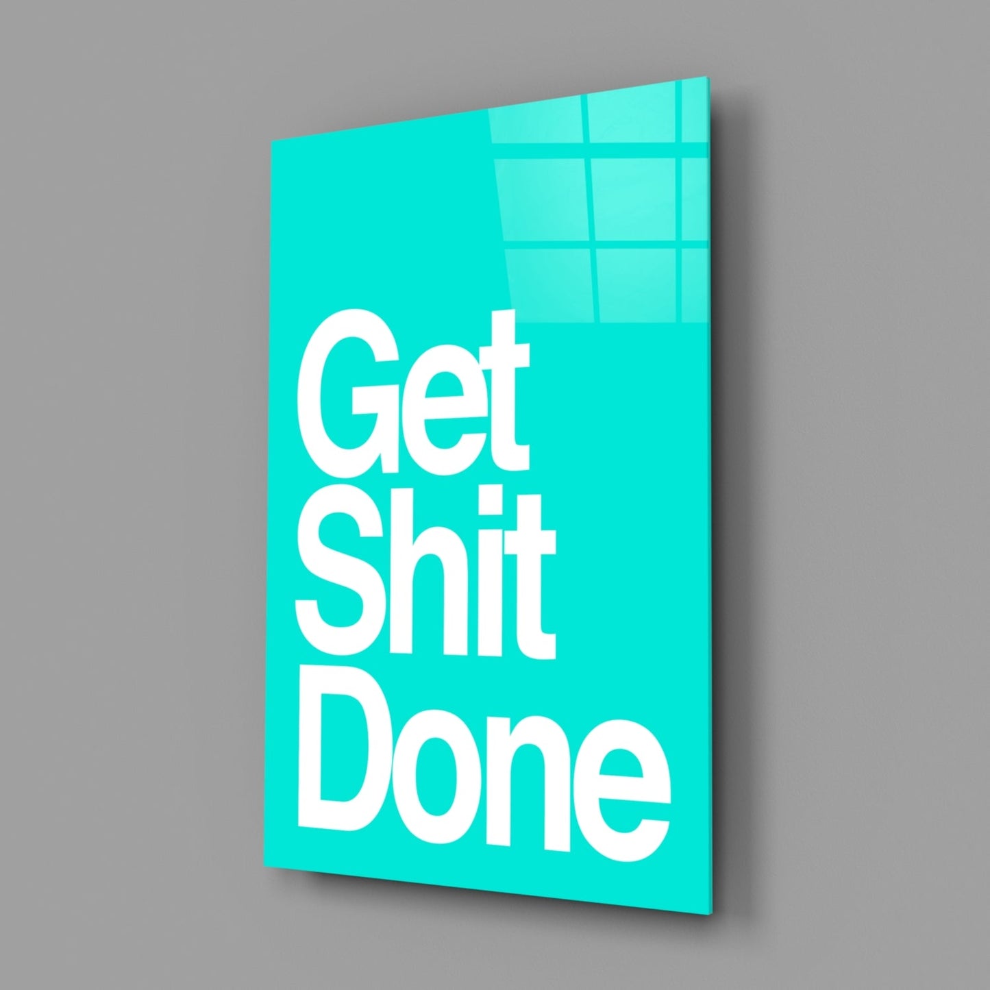 Turquoise glass wall art panel displaying "Get Shit Done" in white sans-serif text, angled three-quarter view against gray background.