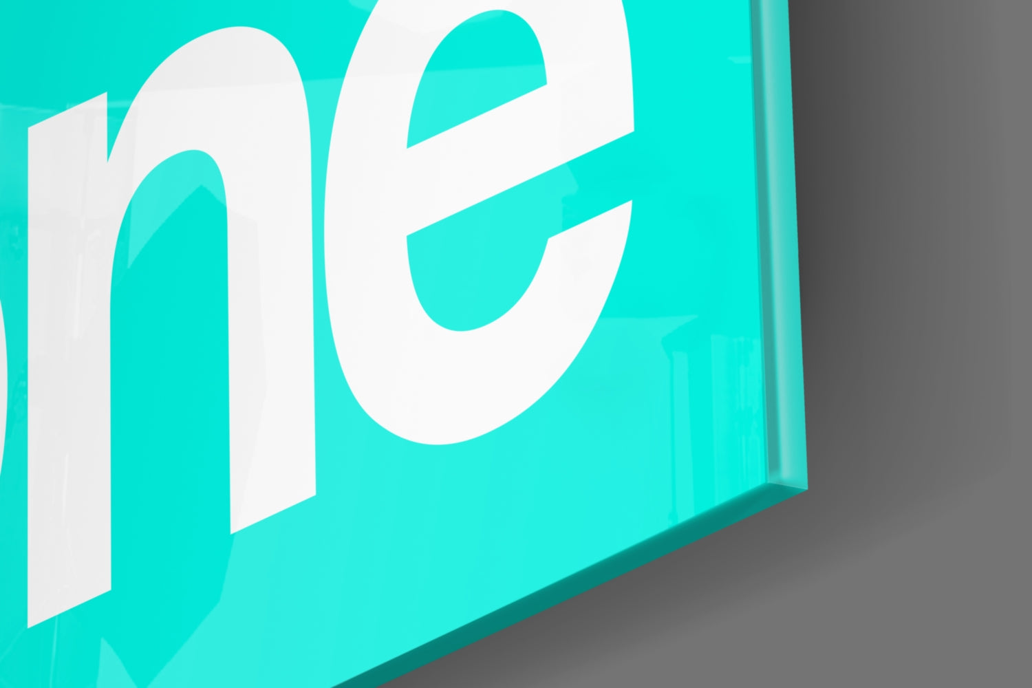 Isometric view of turquoise glass wall art with white "GSD" lettering against gray background.