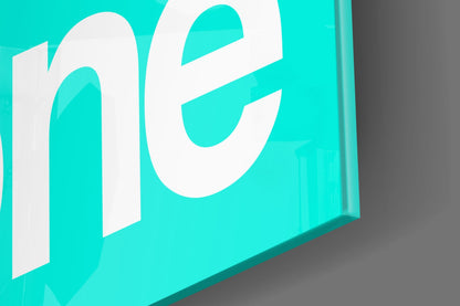 Isometric view of turquoise glass wall art with white "GSD" lettering against gray background.