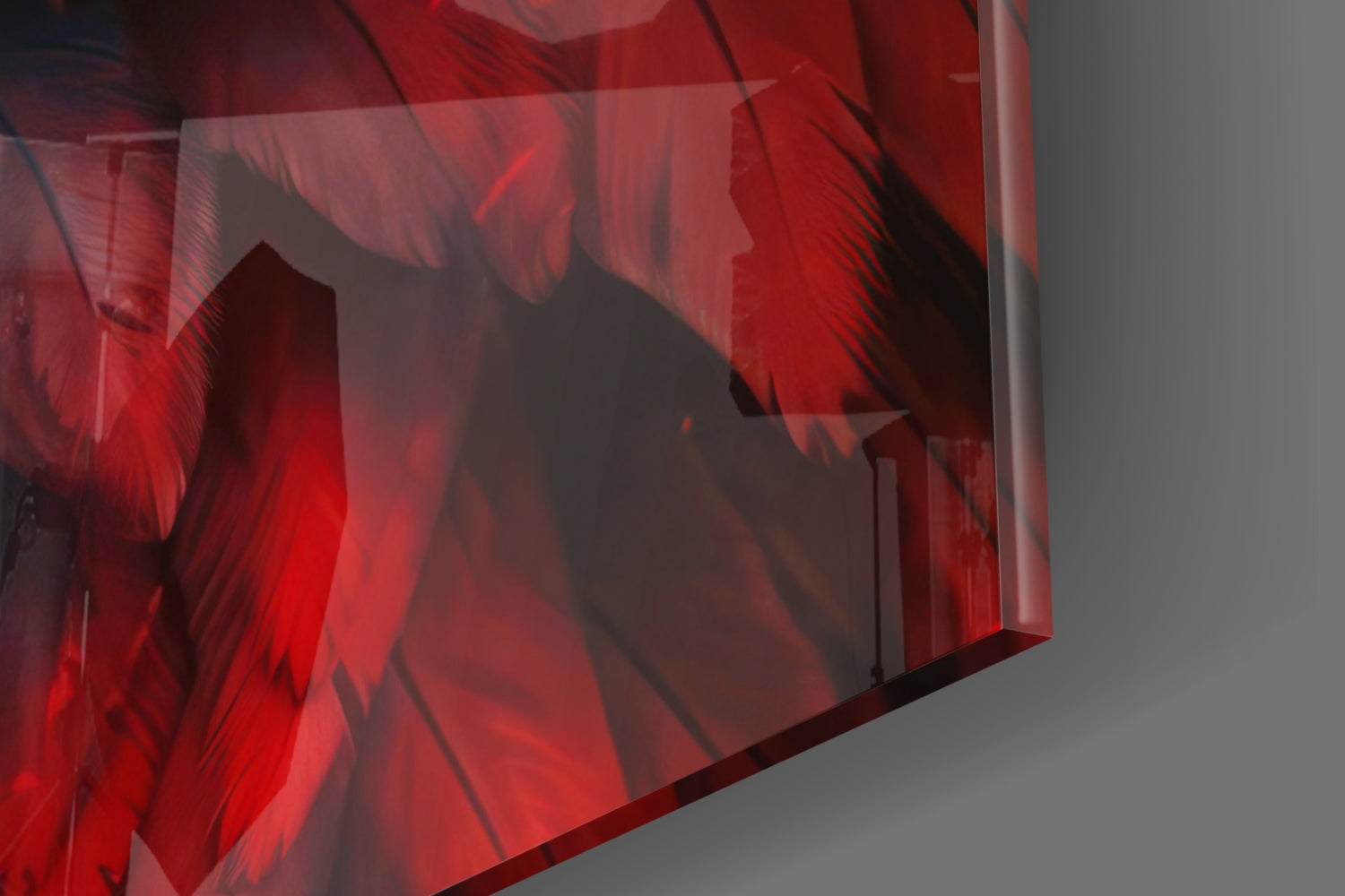 Close-up angled view of translucent red glass wall art with layered eagle silhouette design and shadow details against gray background.