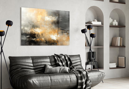 Modern living room with abstract glass wall art featuring gold and gray tones displayed above a black leather sofa.