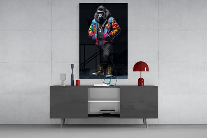 Stylized gorilla wearing colorful geometric jacket and gold boots displayed on wall above modern gray console table with red lamp.
