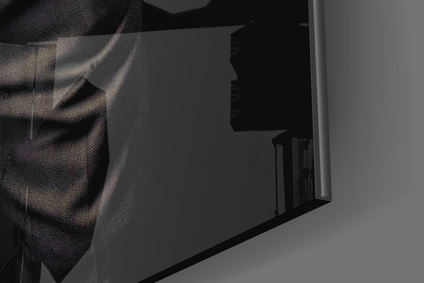 Close-up detail of textured fabric draping across corner of dark glass panel with silhouetted profile visible behind.
