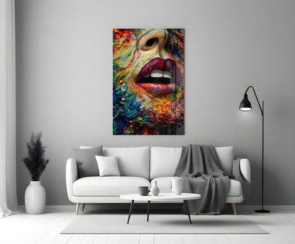 Colorful glass wall art depicting a woman's face with vibrant multicolored patterns and bold pink lips, displayed above a white sofa in a minimalist interior setting.