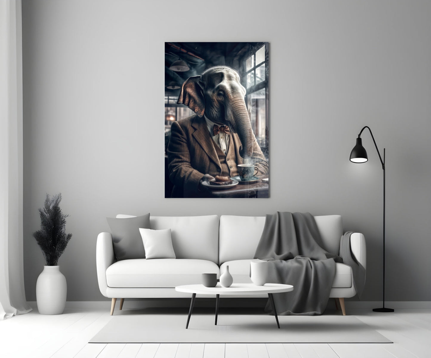Framed glass wall art depicting an elephant in business attire seated at a table with coffee, displayed above a white sofa in a modern living room.