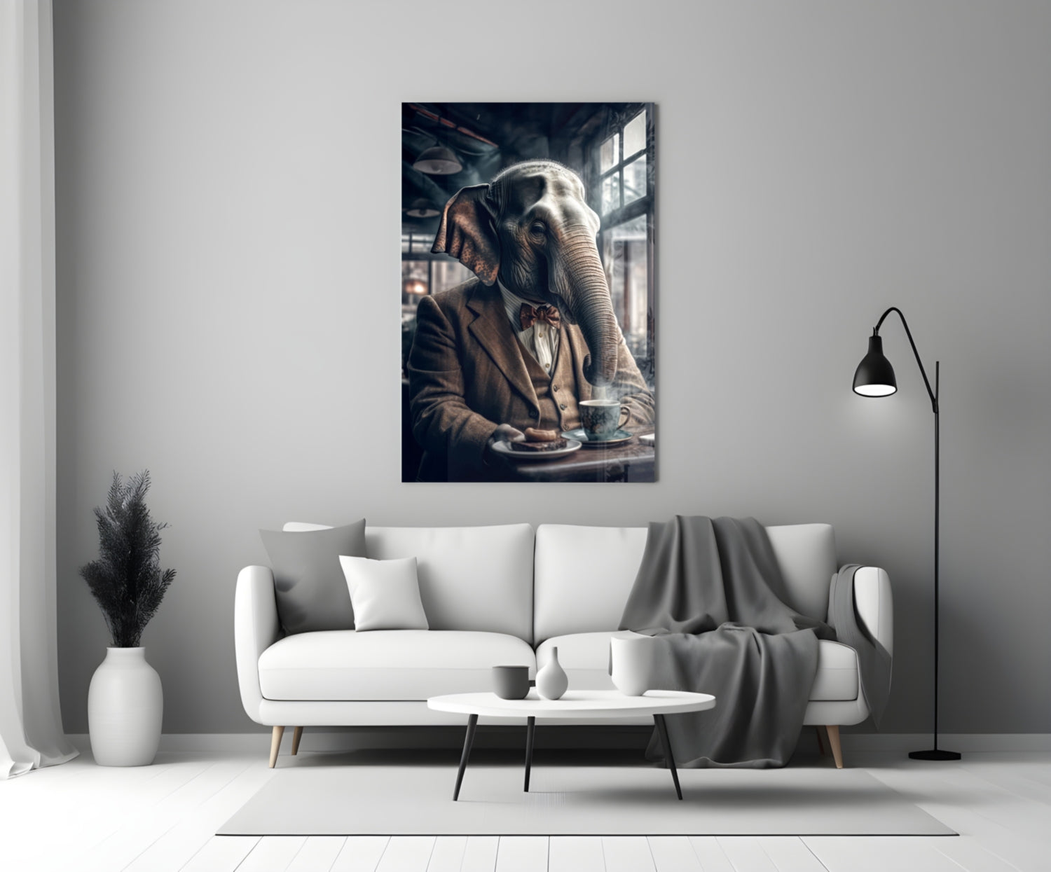 Framed glass wall art depicting an elephant in business attire seated at a table with coffee, displayed above a white sofa in a modern living room.
