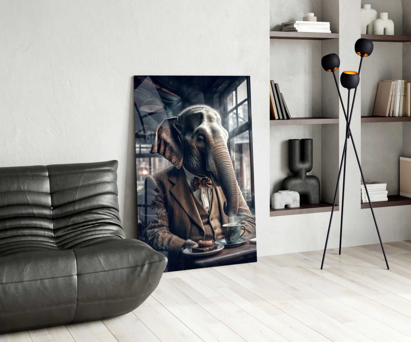 Glass wall art depicting an elephant in business attire with coffee cup, displayed in modern living room with gray sofa and shelving.