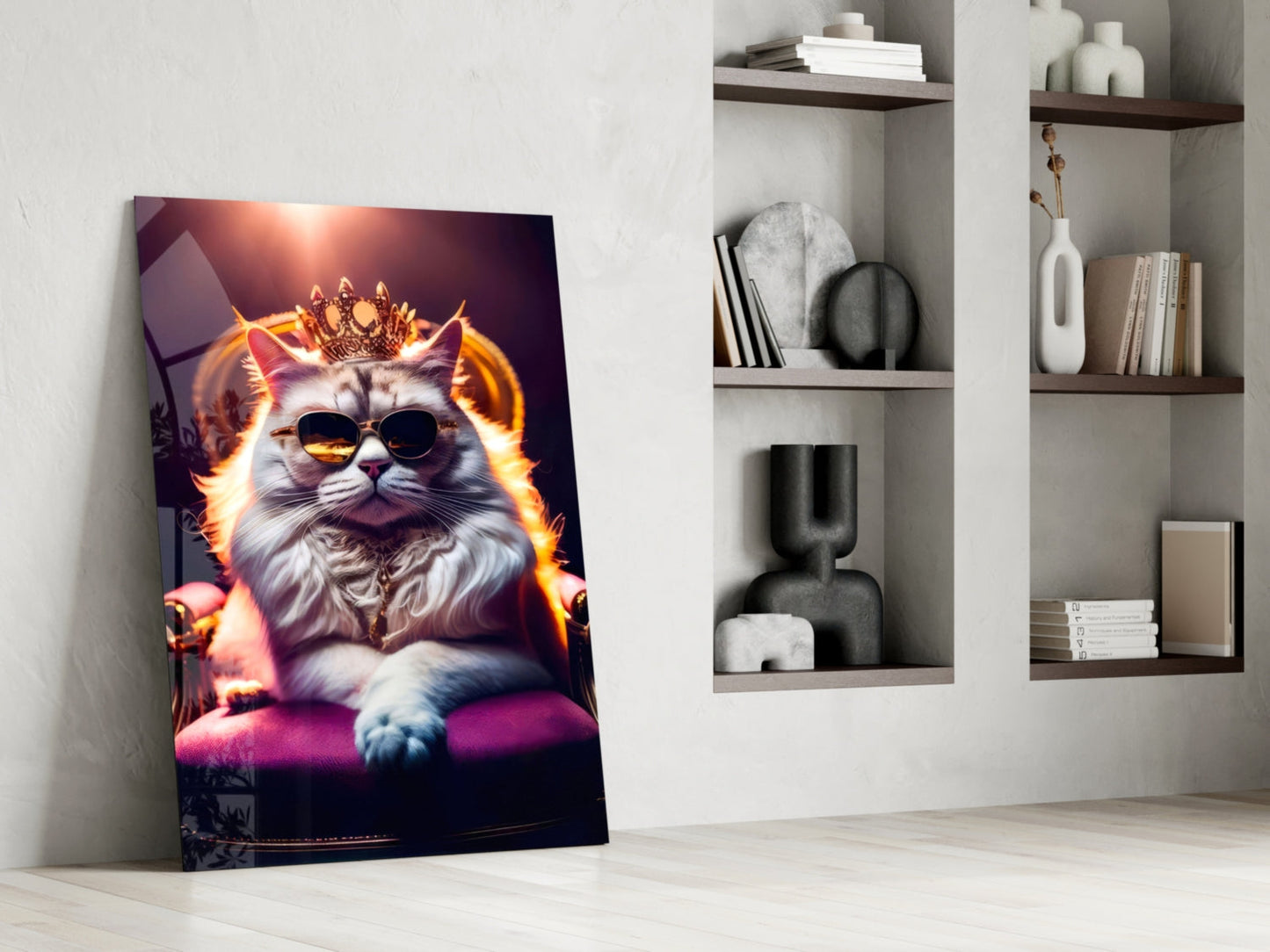 Regal fluffy cat wearing sunglasses and crown with glowing orange aura on purple cushion, displayed as glass wall art leaning against white wall beside shelving.
