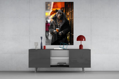 Glass wall art depicting an anthropomorphic leopard in black coat holding a beverage, displayed above a modern gray console table in an interior setting.