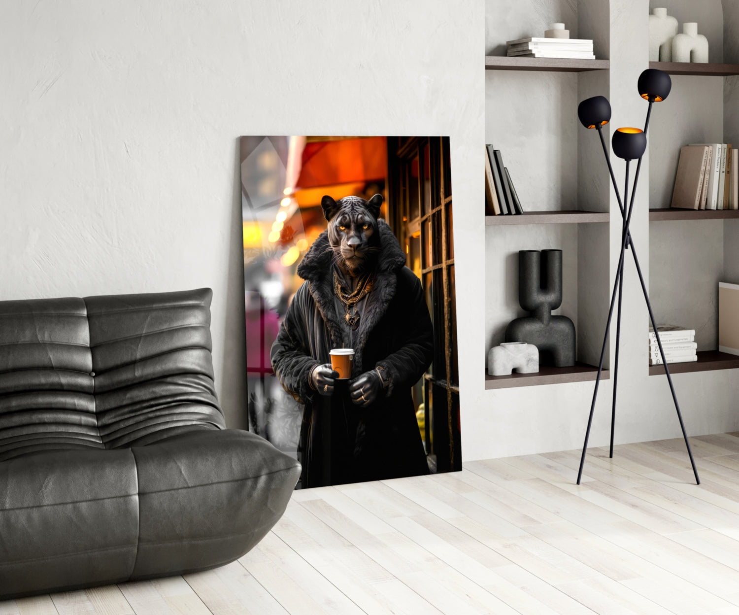 Modern living room interior featuring Java the Leopard glass wall art leaning against white wall beside gray leather chair and shelving unit.