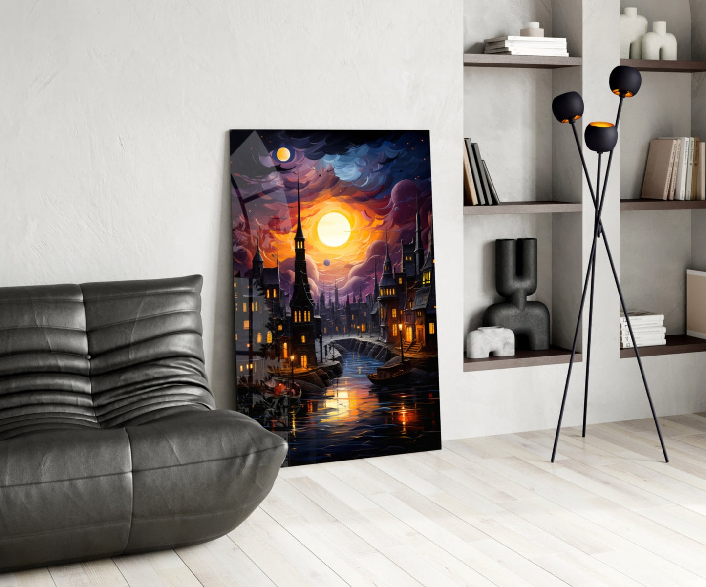 Moonlit cityscape glass art leaning against white wall beside gray leather chair and floor lamp.